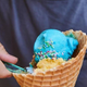 Hand scooping spoon into cone of Blue Moon ice cream